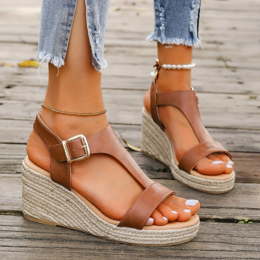 Woman wearing comfortable espadrille wedge T-strap sandals, perfect for a chic summer outfit.