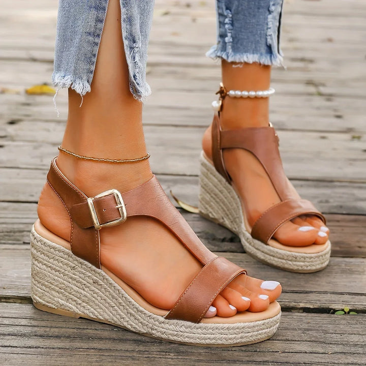 Woman wearing comfortable espadrille wedge T-strap sandals, perfect for a chic summer outfit.