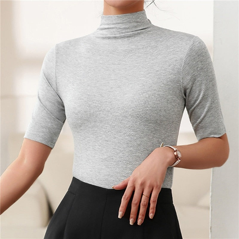 Soft, fitted women's turtleneck top with elbow sleeves, a versatile wardrobe staple for casual chic outfits.