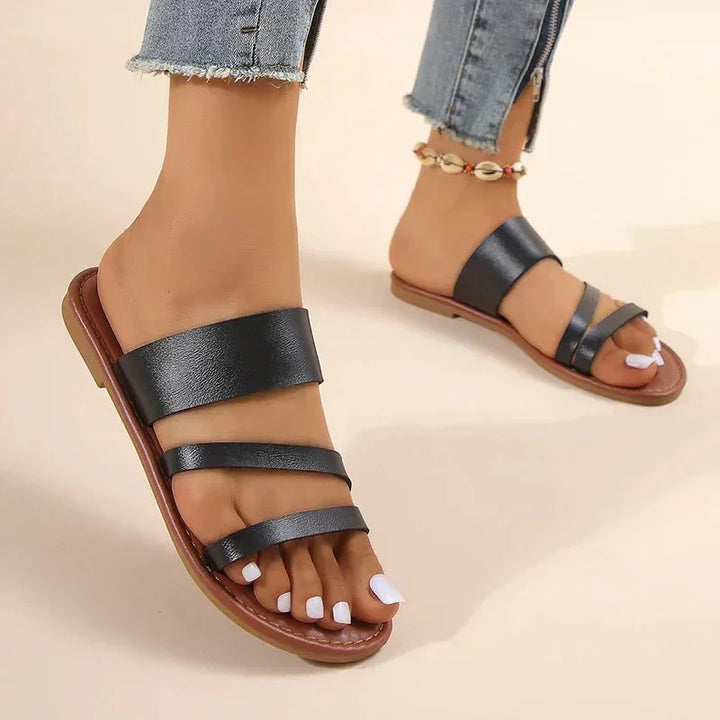 Comfortable women's flat sandals, cushioned multi-strap design, open-toe slip-on for all-day wear.