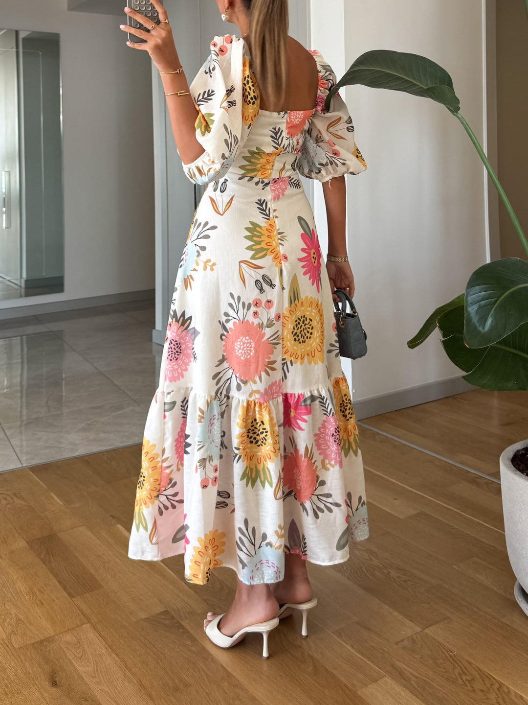 Chic midi dress featuring a vibrant floral print and flattering puff sleeves for a stylish look.