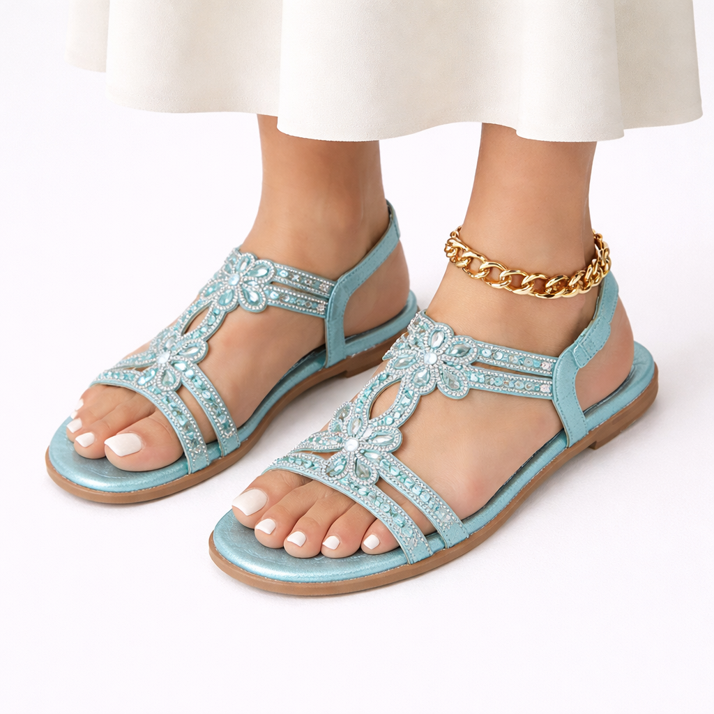 Slip-on women's sandals featuring intricate floral design & sparkling crystal embellishments. Beach ready comfort.