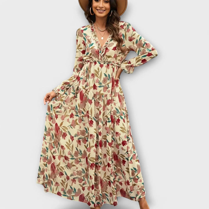 Vibrant women's floral print maxi dress with ruffled V-neck and elegant tiered skirt. Spring/summer style.