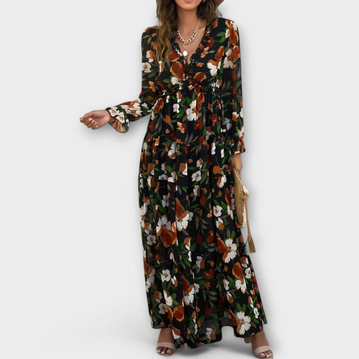 Full view of a women's long floral maxi dress, ruffled V-neck and beautiful tiered skirt. Day/evening wear.