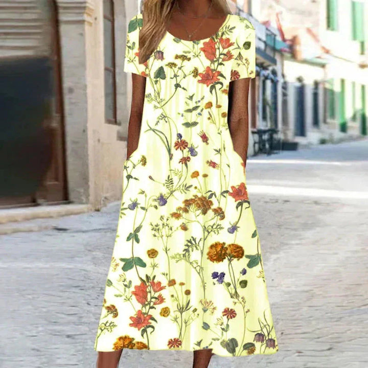 Stylish women's floral midi dress with short sleeves, scoop neck, and functional pockets; ideal for summer fashion.