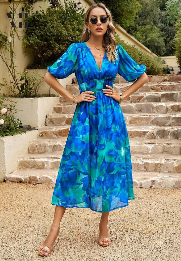 Women's floral print midi dress in a bright outdoor setting, perfect for spring fashion.