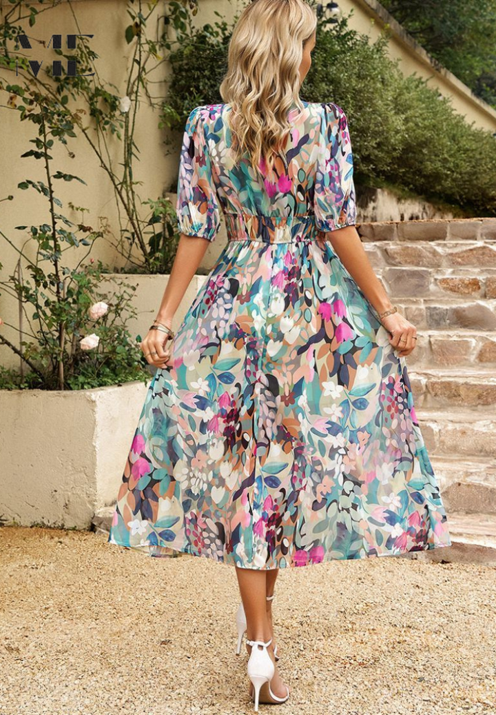 Close-up of vibrant floral pattern on women's V-neck midi dress with short sleeves.