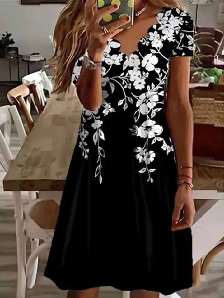 Vibrant floral flared midi dress for women, ideal as a casual summer dress or holiday wear. Features scalloped details.