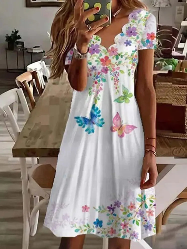 Elegant women's floral midi dress featuring a distinctive scalloped neckline and a flattering flared silhouette.