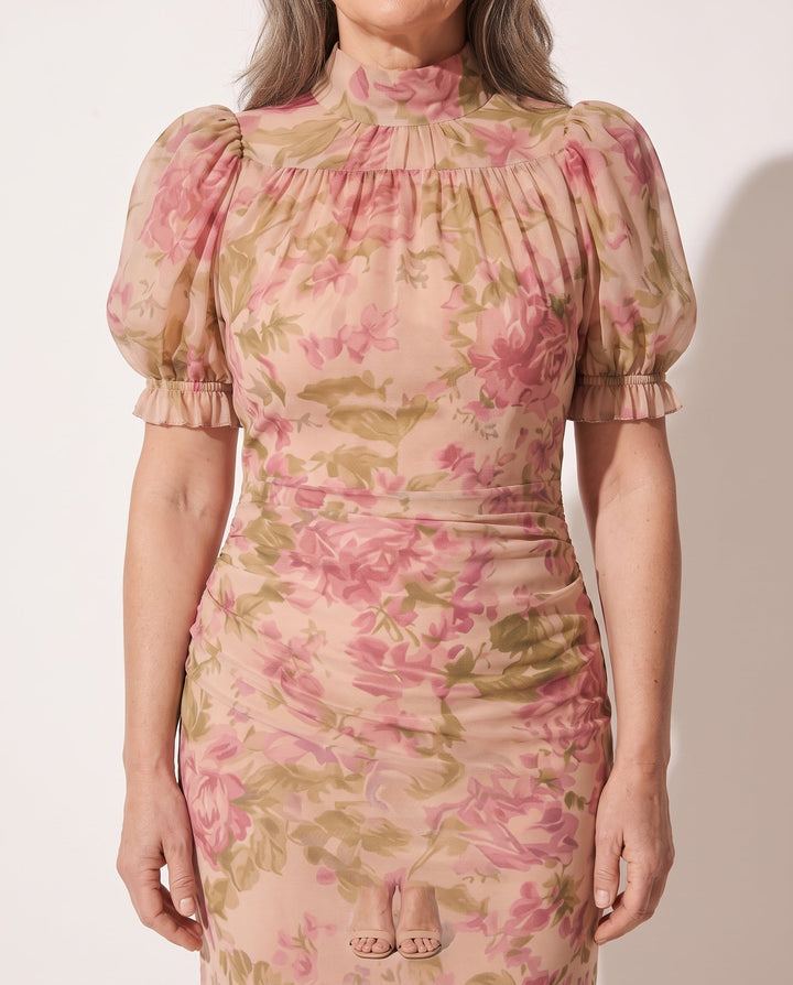 Close-up of women's floral puff sleeve maxi dress, showing ruffle hem & delicate print. Stylish for events.