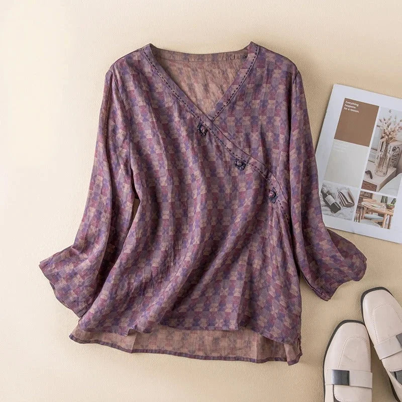 Chic women's V-neck blouse with a vibrant floral print, relaxed fit, 3/4 sleeves, and a practical button-front.