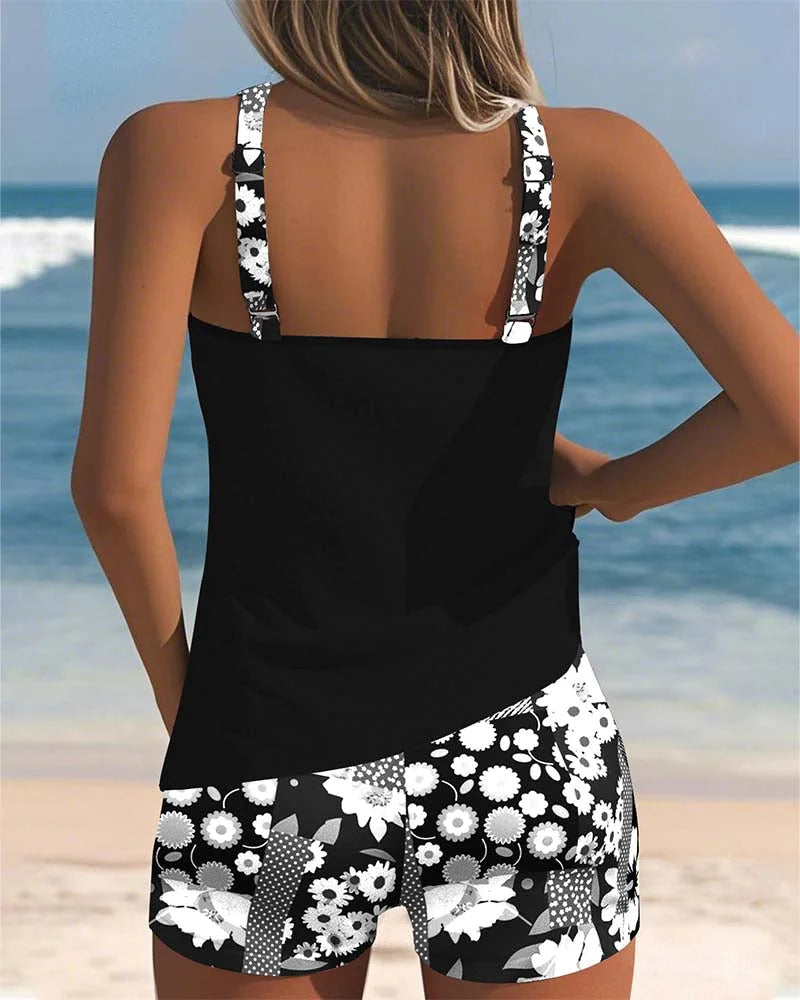 Stylish women's floral print tankini top paired with solid black swim shorts. Modest design.