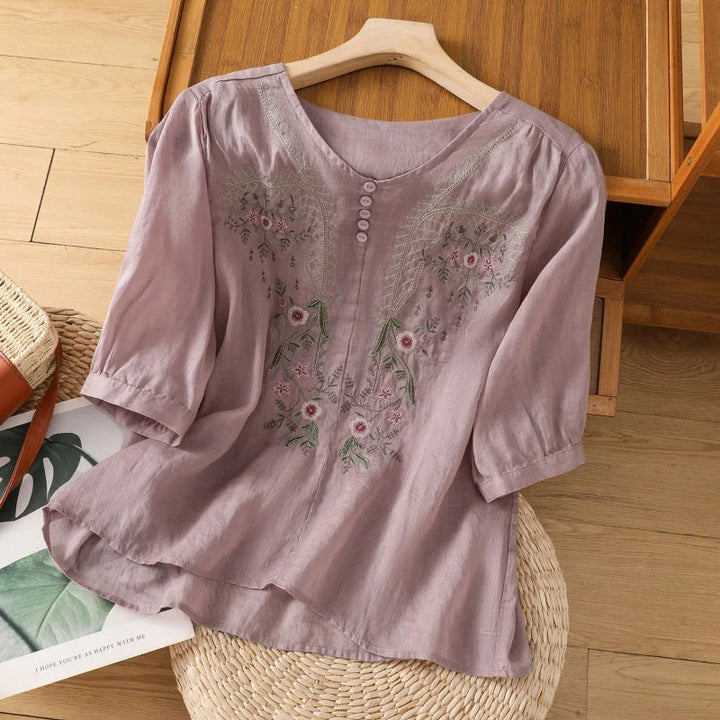 Casual women's floral blouse featuring V-neck and 3/4 sleeves. Relaxed comfort wear for summer fashion.