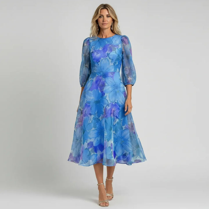 Feminine women's midi dress featuring a vibrant floral pattern and sheer puff sleeves.