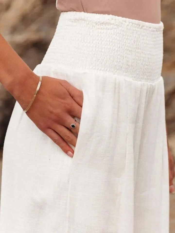 Chic women's wide leg pants, featuring a comfortable smocked high-waist. Flowing design for relaxed elegance.