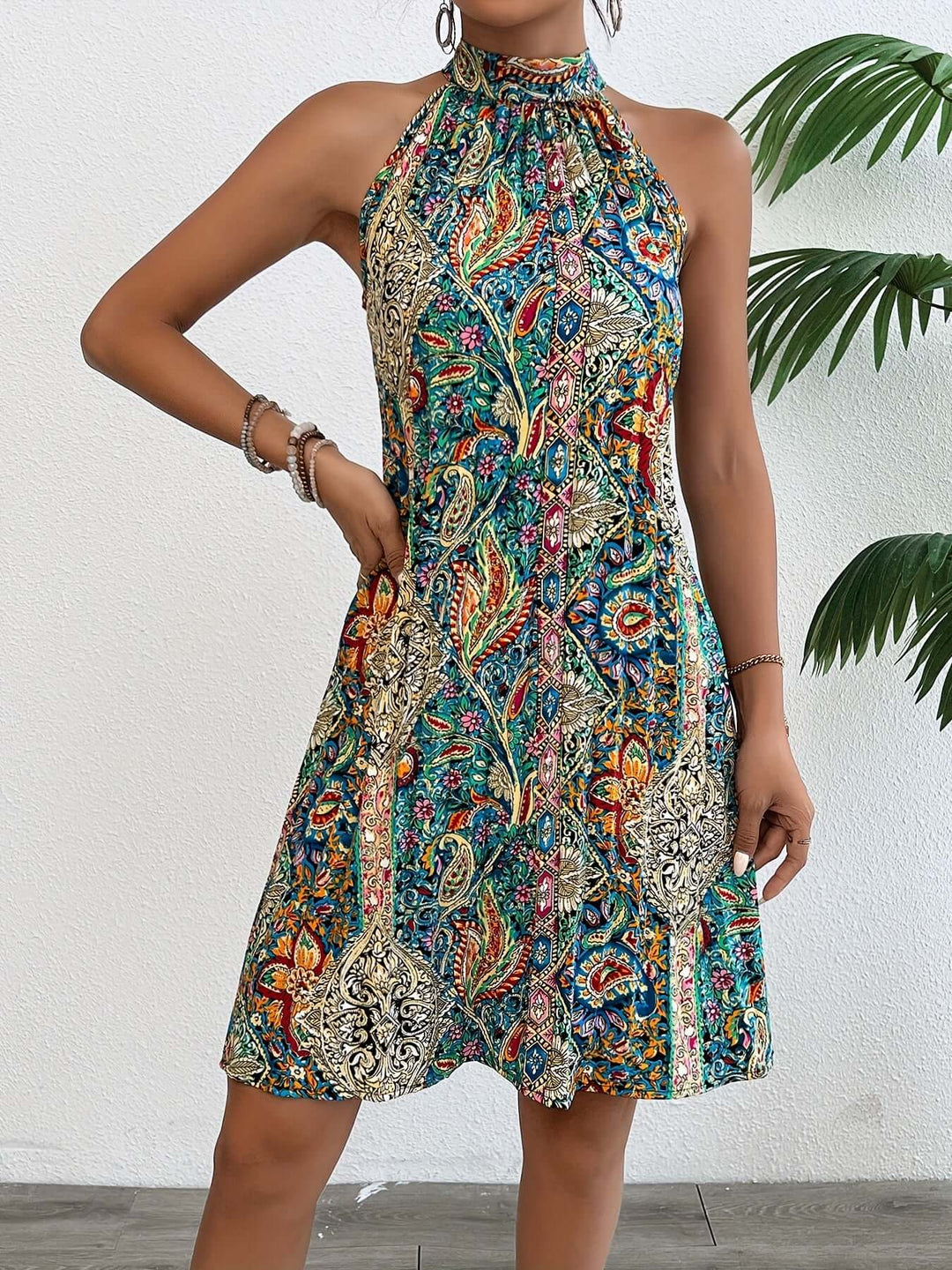 Women's flowy boho halter dress in a vibrant paisley print, perfect for effortless summer style and beach vacations.