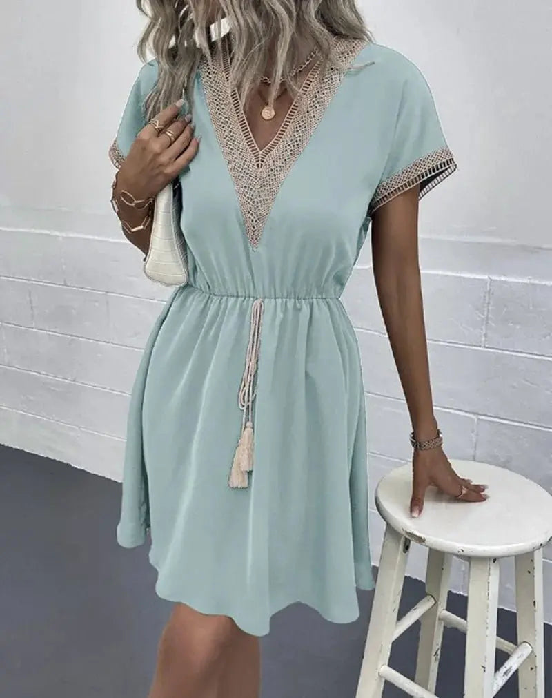 White bohemian V-neck midi dress with tie waist and short sleeves, an elegant choice for beach or day.
