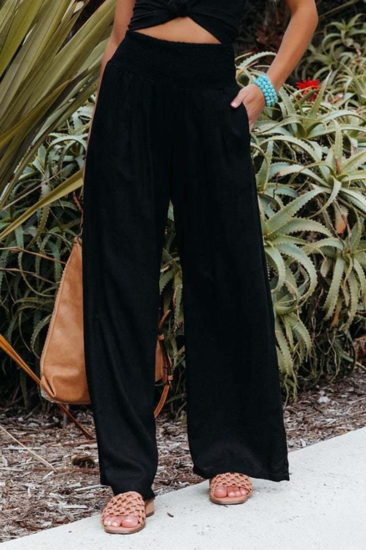 Textured linen women's wide leg trousers with a shirred waist, made from breathable fabric.
