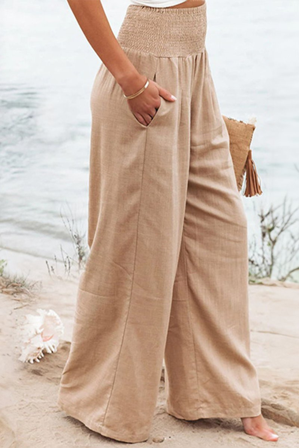 Women's linen wide leg trousers with a shirred elasticated waist, offering a comfortable, relaxed fit.