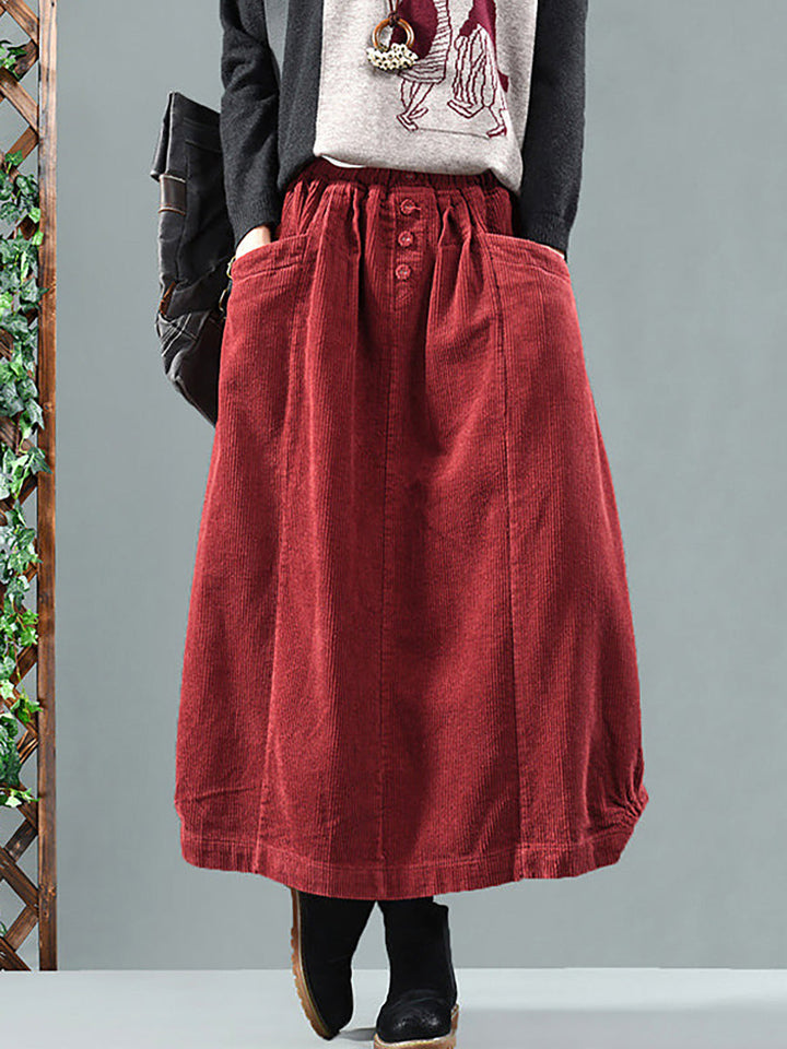 Women's flowy pleated maxi skirt with functional buttons & convenient pockets, ideal for casual wear.