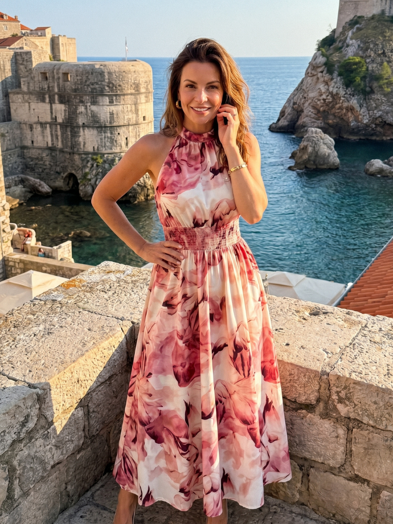 Vacation-ready abstract print midi dress for women. Features a chic gathered waist.