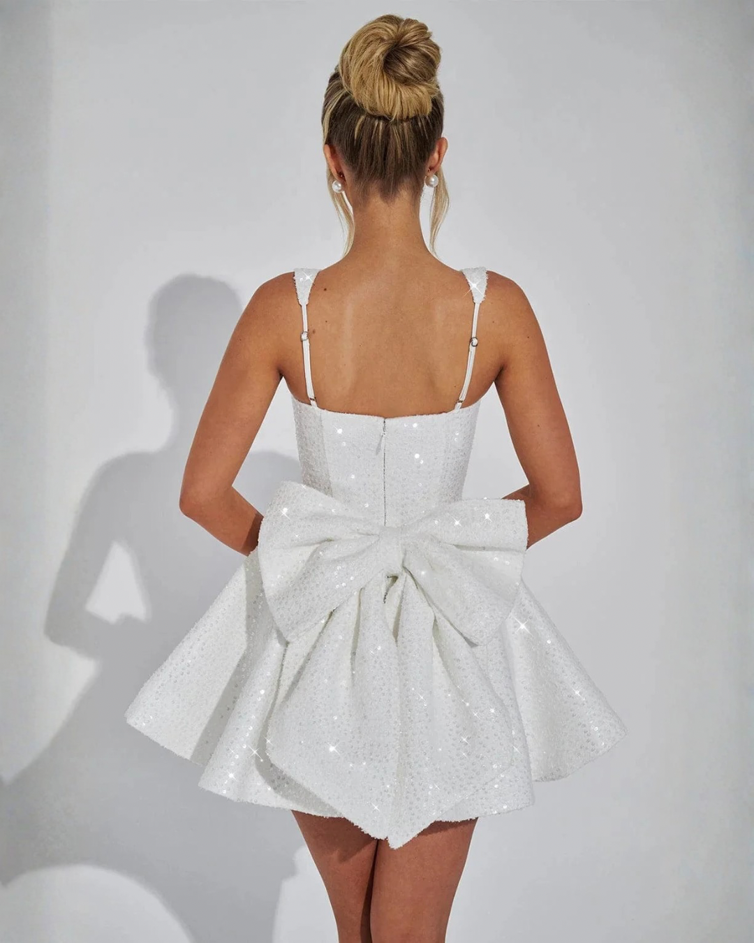 Sparkling women's sequin mini dress. Square neck & bow detail create a chic, fitted silhouette for evening events.