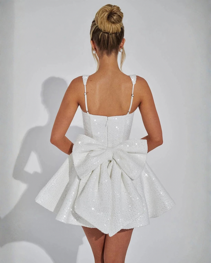 Sparkling women's sequin mini dress. Square neck & bow detail create a chic, fitted silhouette for evening events.