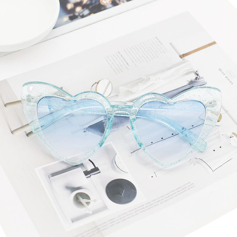 Women's trendy glitter heart sunglasses, a stylish fashion accessory. Offers excellent UV protection for all-day wear.
