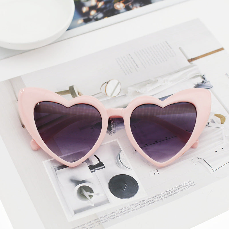 Dazzling women's heart sunglasses with glitter detail. Trendy eyewear providing UV protection, ideal for sunny fashion.