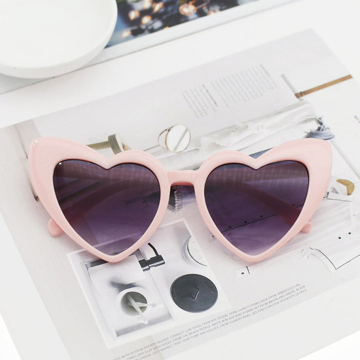 Dazzling women's heart sunglasses with glitter detail. Trendy eyewear providing UV protection, ideal for sunny fashion.