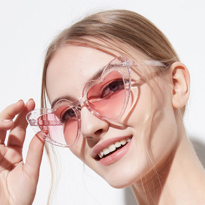 Sparkling heart-shaped glitter sunglasses for women, offering stylish UV protection. A must-have summer accessory.