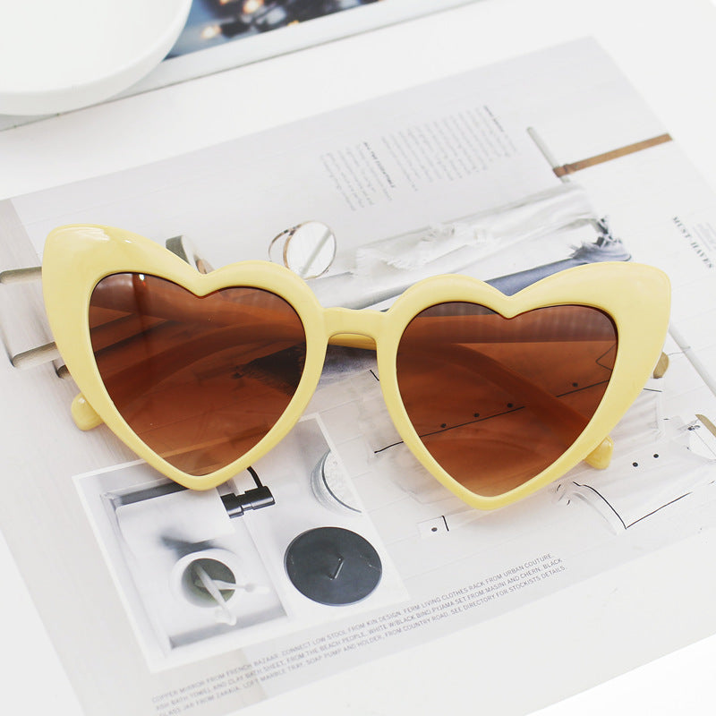 Trendy women's heart sunglasses with glitter finish. Fashionable eyewear providing essential UV protection for sunny days.