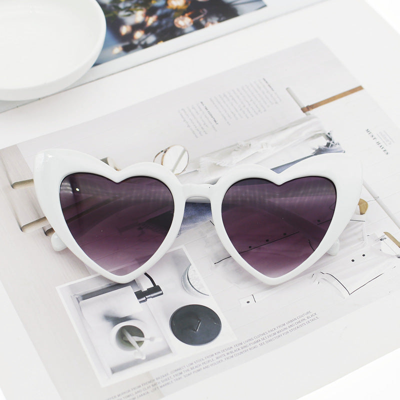 Playful heart-shaped glitter sunglasses for women. Trendy eyewear with UV protection, perfect for a fun summer.