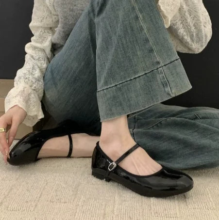 Women's glossy black Mary Jane shoes with comfortable low block heel. Classic, polished dress or casual footwear.
