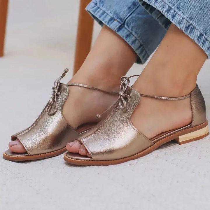 Casual silver metallic flat open-toe sandals for women, featuring a chic bow tie and secure ankle strap.