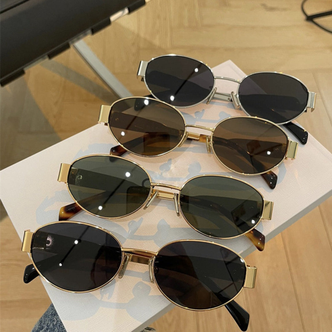 Women's green oval designer sunglasses with UV protection, stylish fashion accessory.
