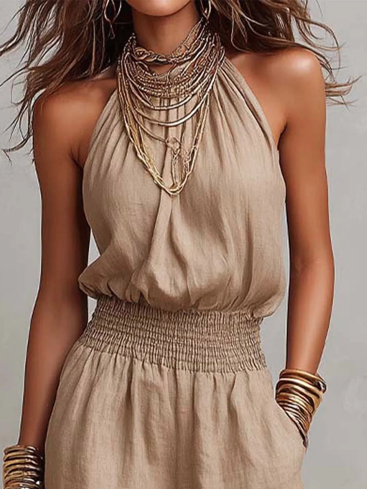 Comfortable women's backless wide-leg jumpsuit with halter neck & smocked waist. Ideal for casual summer fashion.