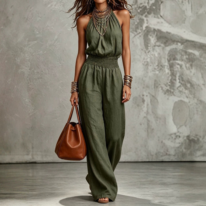 Sleeveless women's halter neck backless wide-leg jumpsuit with smocked waist for a chic, relaxed fit & summer style.