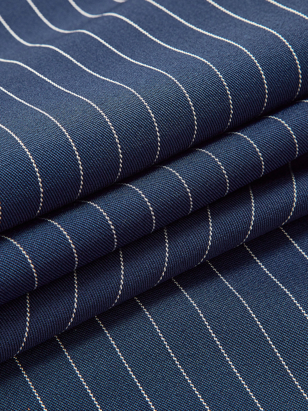 Close-up of elegant women's pinstripe wide leg trousers fabric, highlighting texture and chic design.