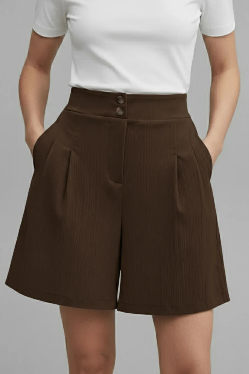 Women's summer fashion: high waist pleated Bermuda shorts with a button front, embodying tailored comfort.