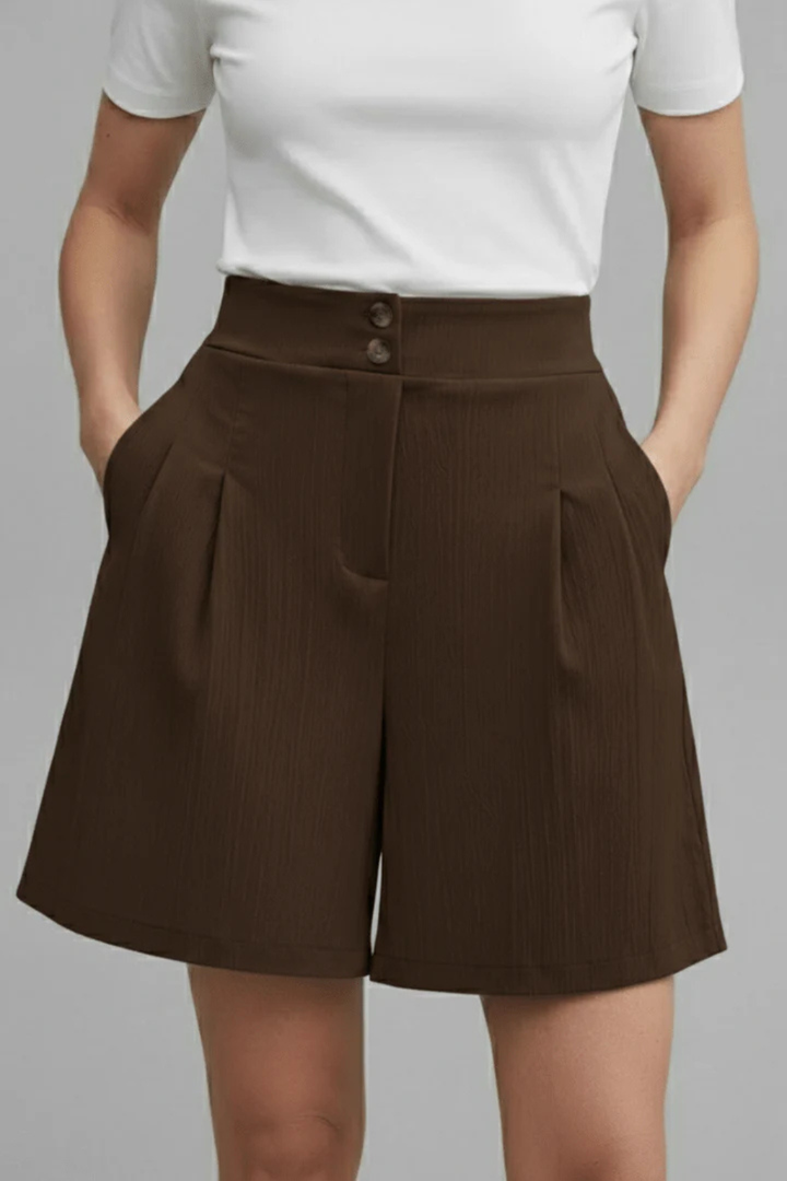 Women's summer fashion: high waist pleated Bermuda shorts with a button front, embodying tailored comfort.