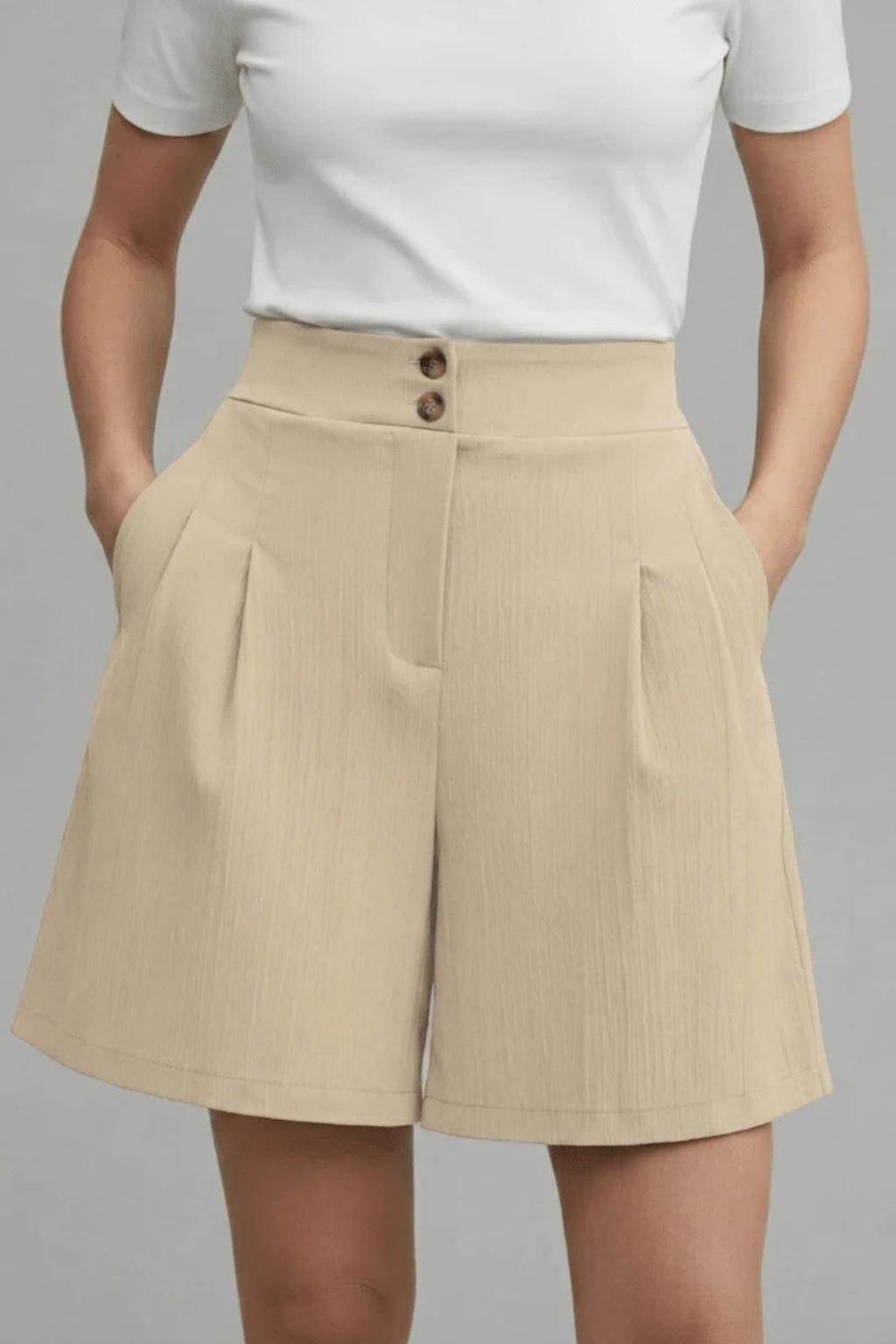 Button-front women's Bermuda shorts, high-waisted and pleated. Tailored for modern casual summer fashion.