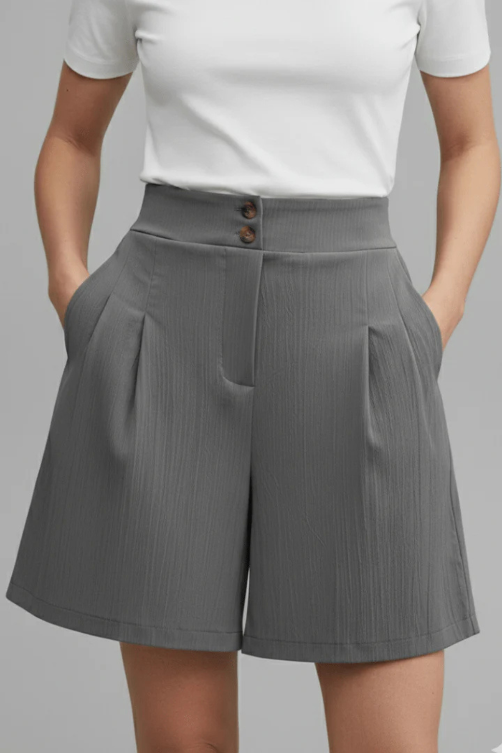 Stylish pleated Bermuda shorts for women, featuring a high waist and a sophisticated tailored design.
