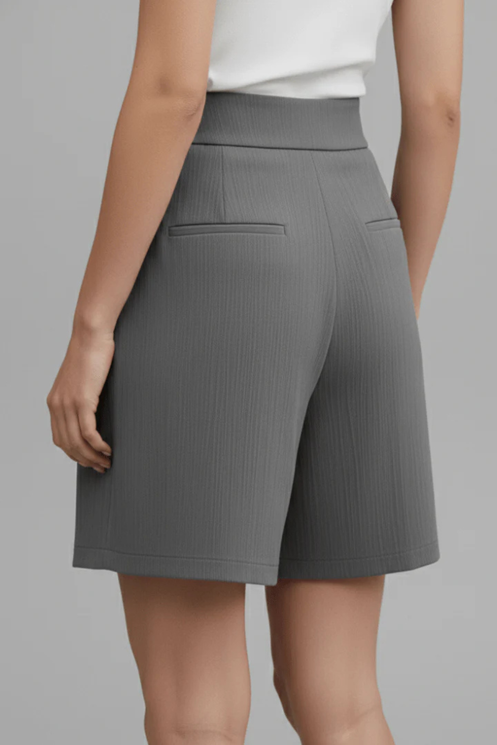 Fashionable women's pleated Bermuda shorts with a high waist and button front. Tailored for summer chic.