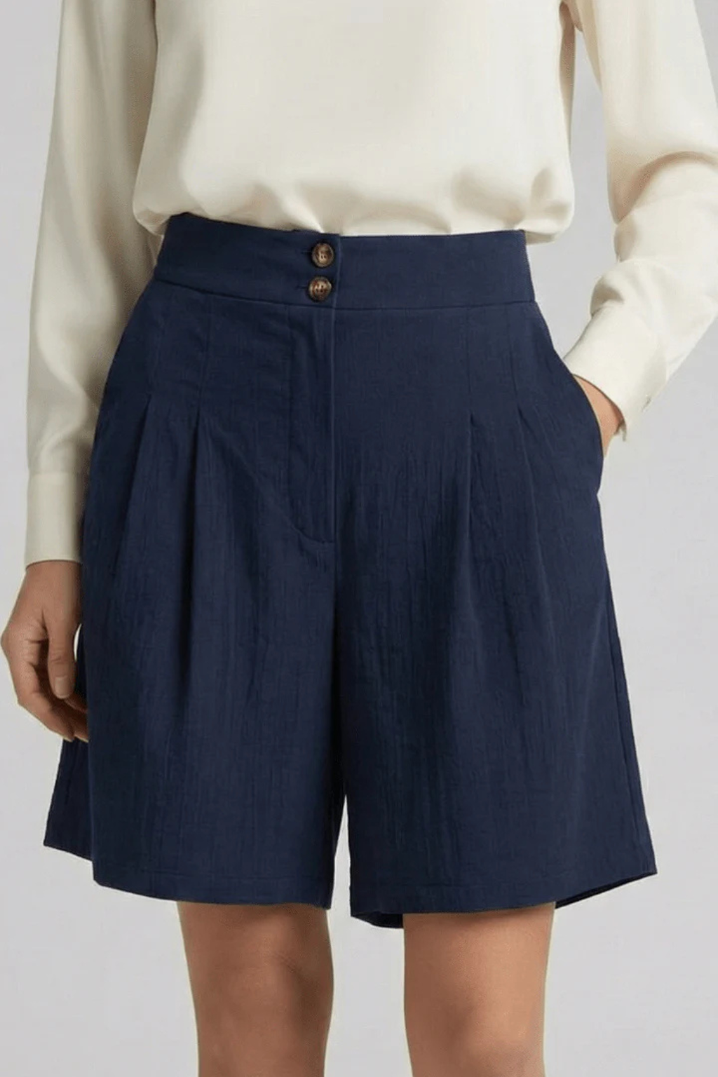 Model wearing stylish women's high waist pleated tailored Bermuda shorts, perfect for summer fashion.