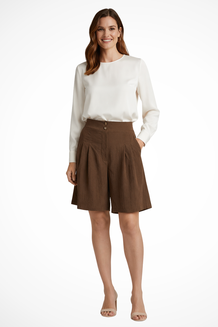 Woman showcasing high waist pleated tailored Bermuda shorts, ideal for office or casual summer days.