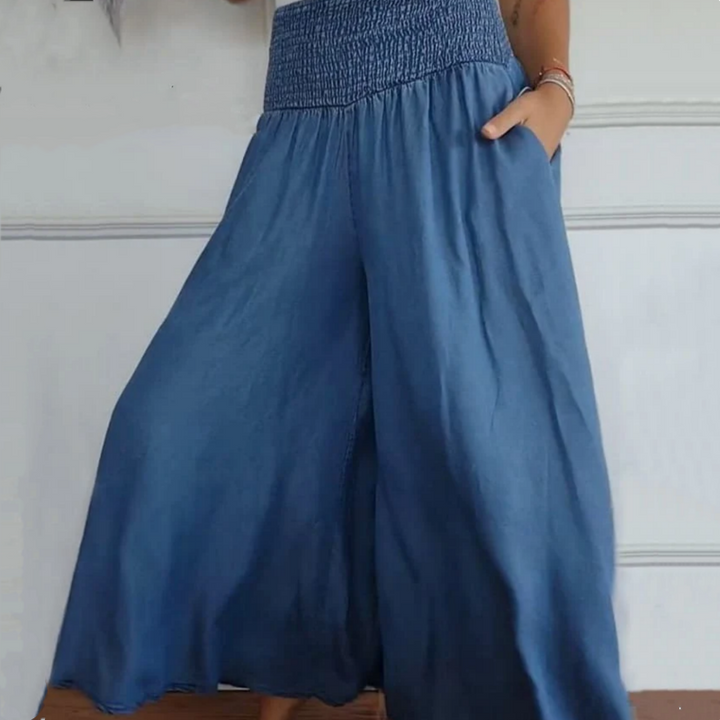 Flowing wide-leg denim trousers for women, featuring a high-waist & smocked waistband for comfort.