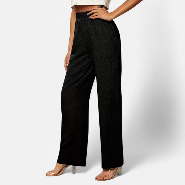 Close-up of the detailed tailoring on women's straight-leg work pants in a rich brown hue.