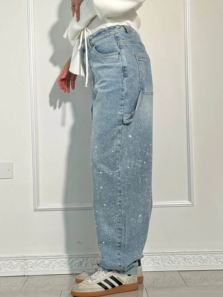 Close-up of crystal details on women's vintage denim high-waist straight leg jeans for elegant sparkle.