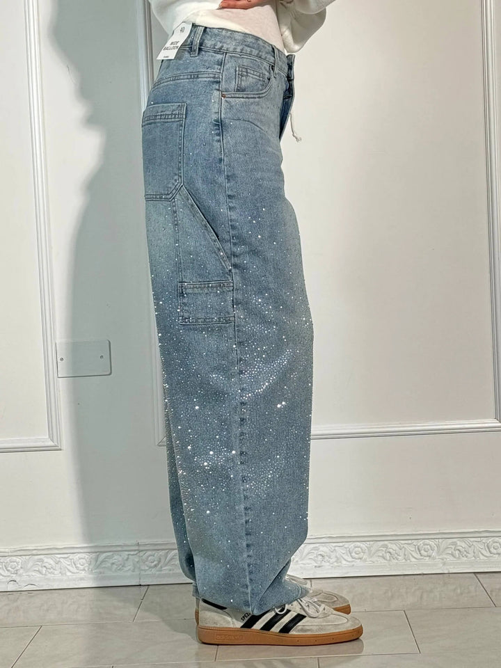 Woman models high-waist straight leg vintage denim jeans with crystals, full length fashion shot.